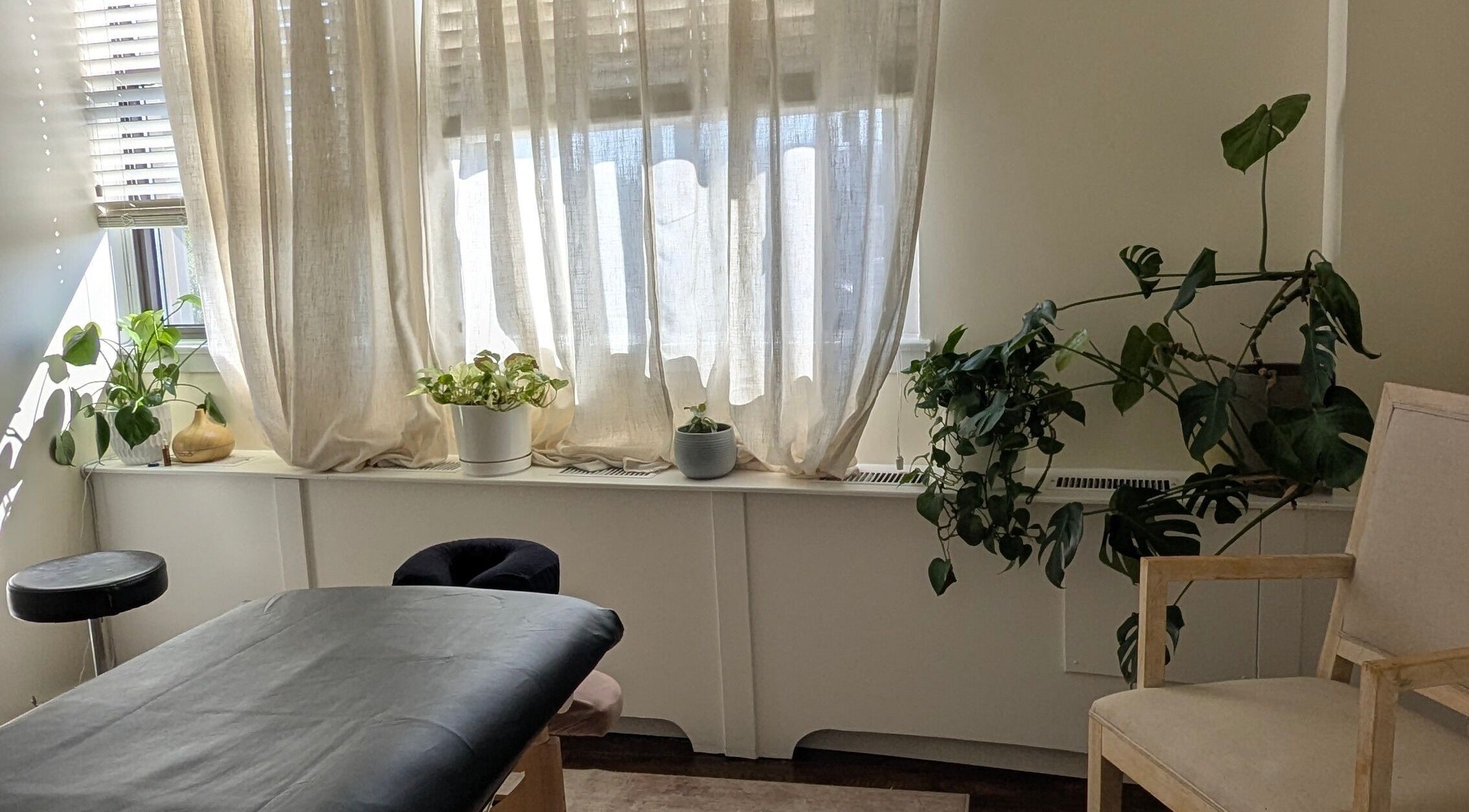 Peaceful treatment room at Ugnayan Pratique Holistique (Westmount), Westmount, Québec, CA with soft lighting.