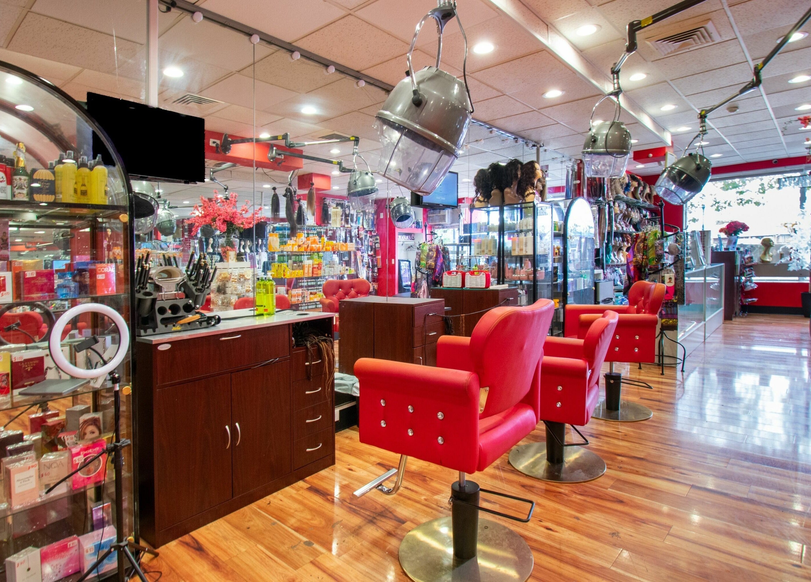 Vibrant interior of Nadege Creation - SOUTH SHORE PLAZA, Braintree, Massachusetts, US with red salon chairs and products.