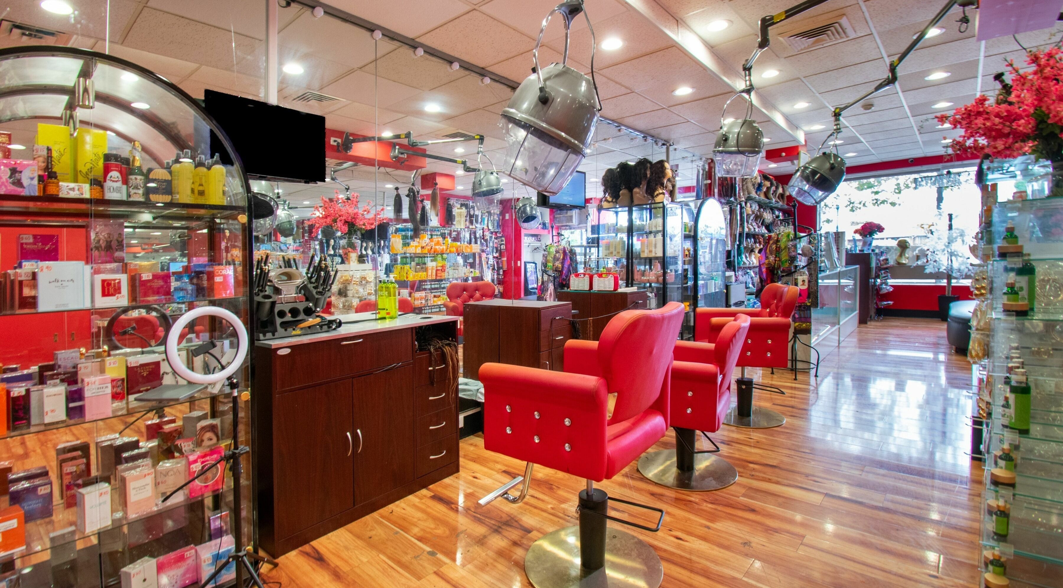 Vibrant interior of Nadege Creation - SOUTH SHORE PLAZA, Braintree, Massachusetts, US with red salon chairs and products.