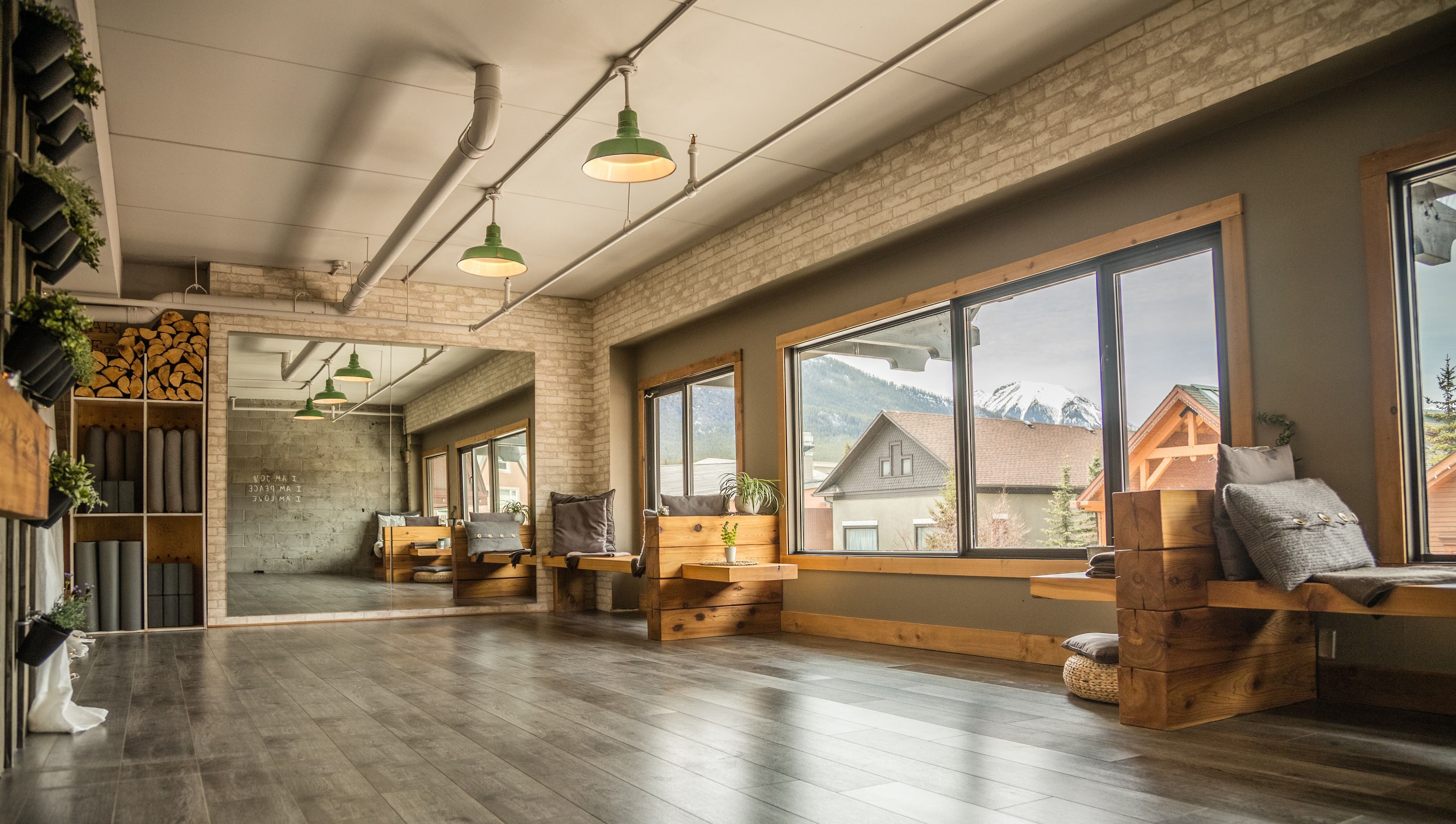 Bright yoga studio at Cedar & Sage Co, Banff, Alberta, CA with mountain views and natural wood accents.