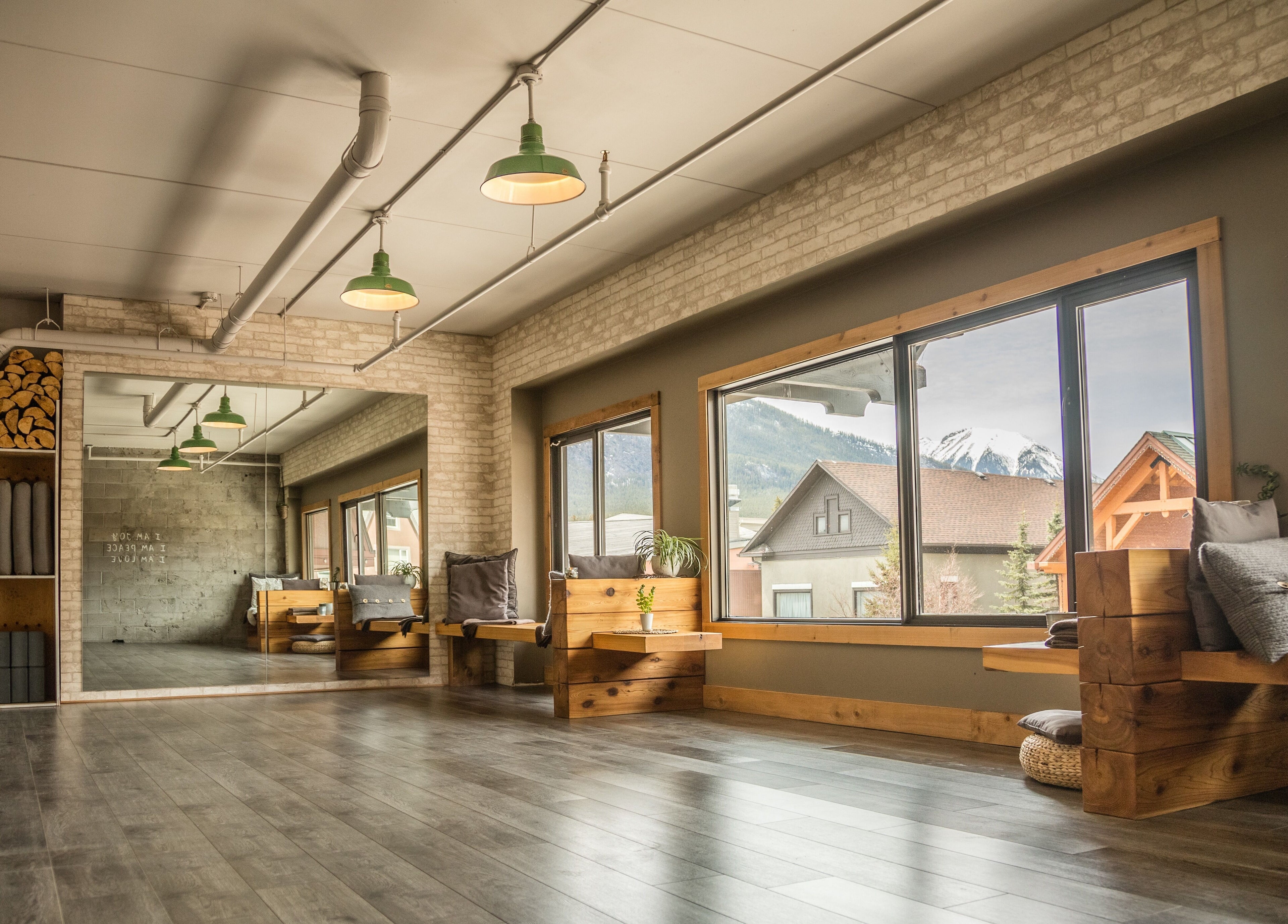 Bright yoga studio at Cedar & Sage Co, Banff, Alberta, CA with mountain views and natural wood accents.