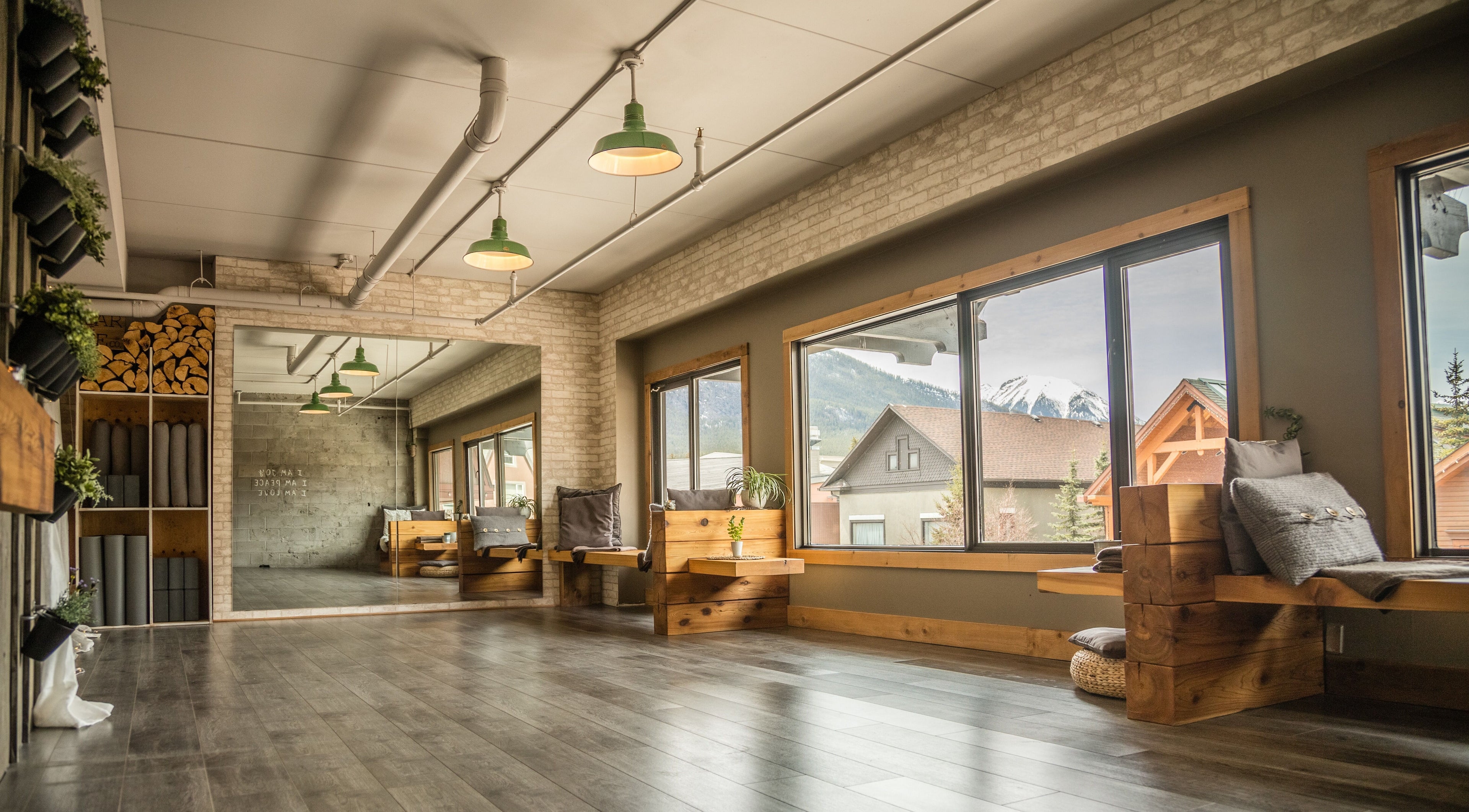 Bright yoga studio at Cedar & Sage Co, Banff, Alberta, CA with mountain views and natural wood accents.