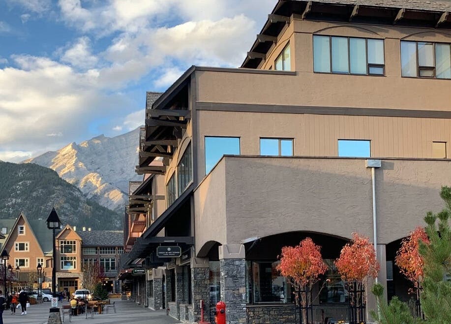 Scenic street view near Cedar & Sage Co, Banff, Alberta, CA, framed by mountains and clear skies.