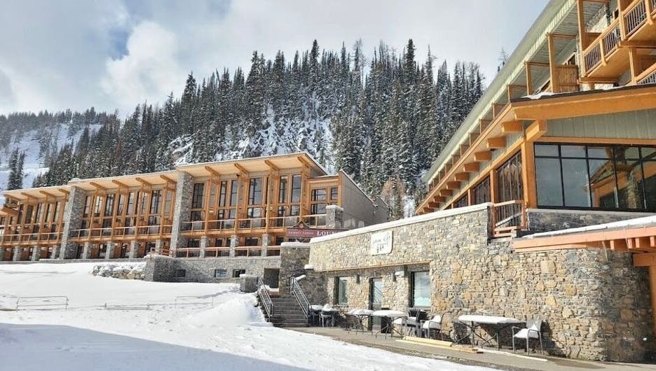 Cedar & Sage Sunshine Village in Banff, Alberta, CA, nestled in snowy alpine landscape with rustic architecture.