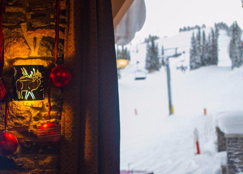 Cozy interior with moose light and red ornaments at Cedar & Sage Sunshine Village, Banff, Alberta, CA.