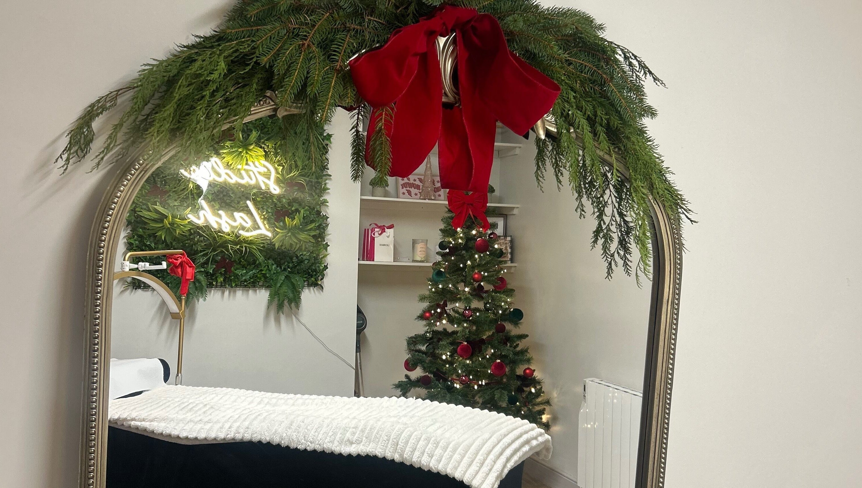 Festive decor at Studio Lash, Leek, England, GB showcasing a mirror with garland and a Christmas tree.