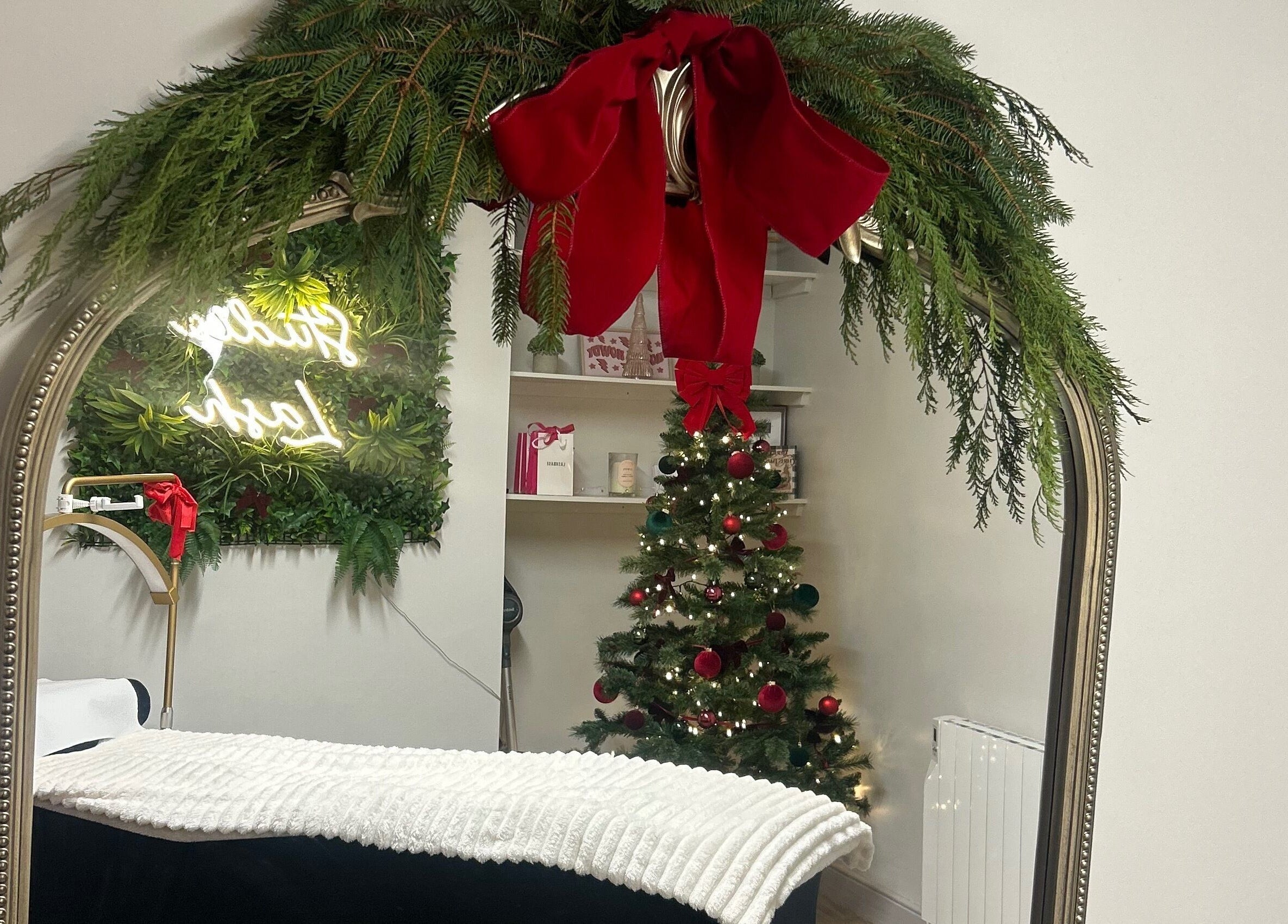 Festive decor at Studio Lash, Leek, England, GB showcasing a mirror with garland and a Christmas tree.