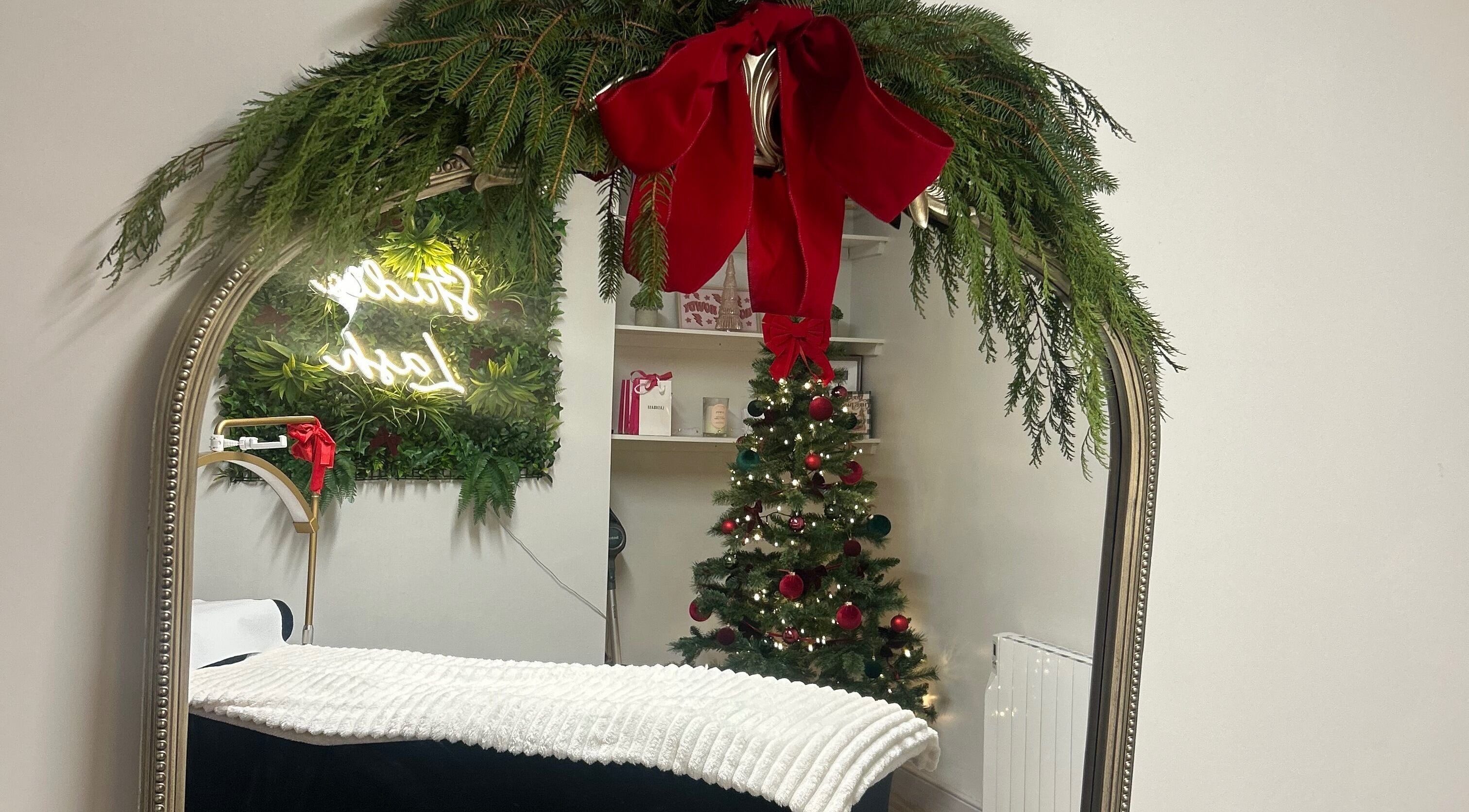 Festive decor at Studio Lash, Leek, England, GB showcasing a mirror with garland and a Christmas tree.