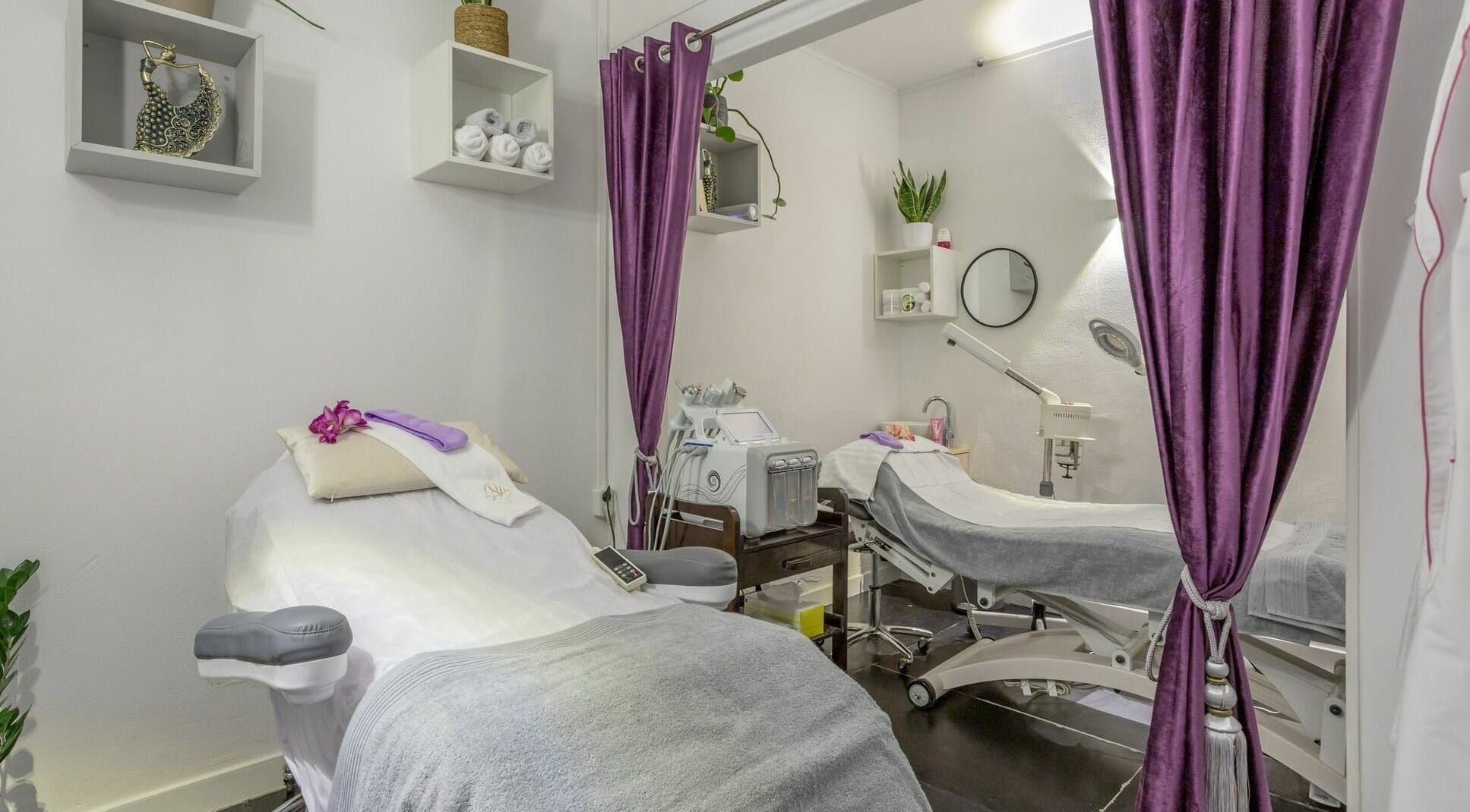 Serene treatment room at Na Thai Spa and Beauty, Amsterdam, Noord-Holland, NL with purple curtains and spa beds.