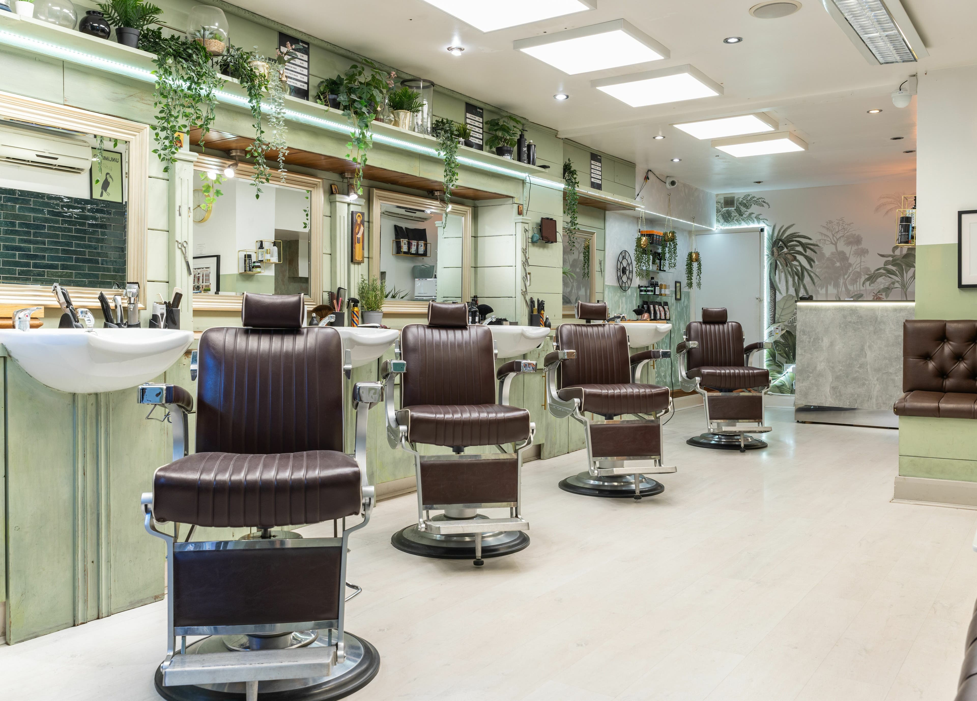 Modern interior of Saints Barbers Crouch End in London, England, GB, featuring sleek chairs and vibrant decor.