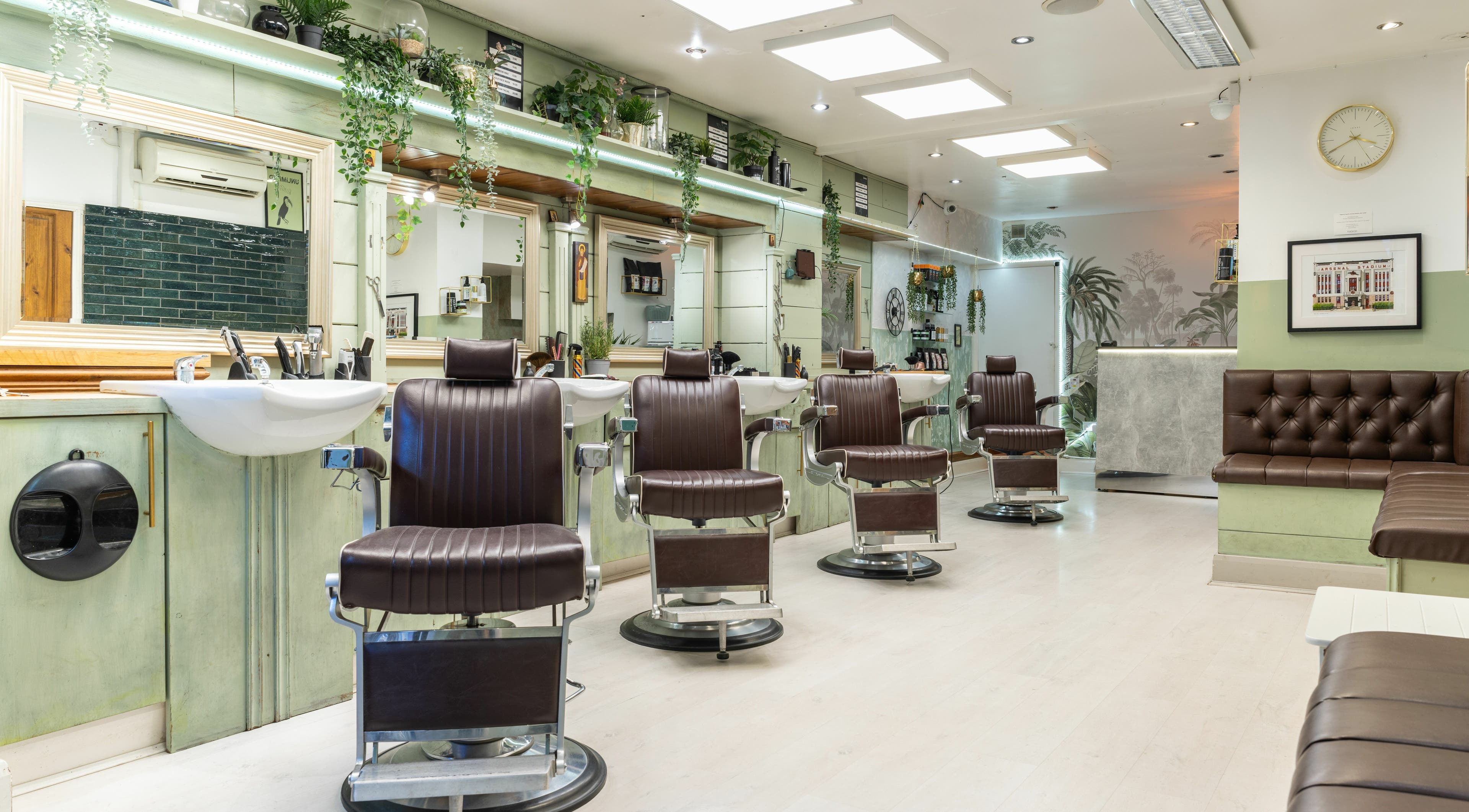 Modern interior of Saints Barbers Crouch End in London, England, GB, featuring sleek chairs and vibrant decor.
