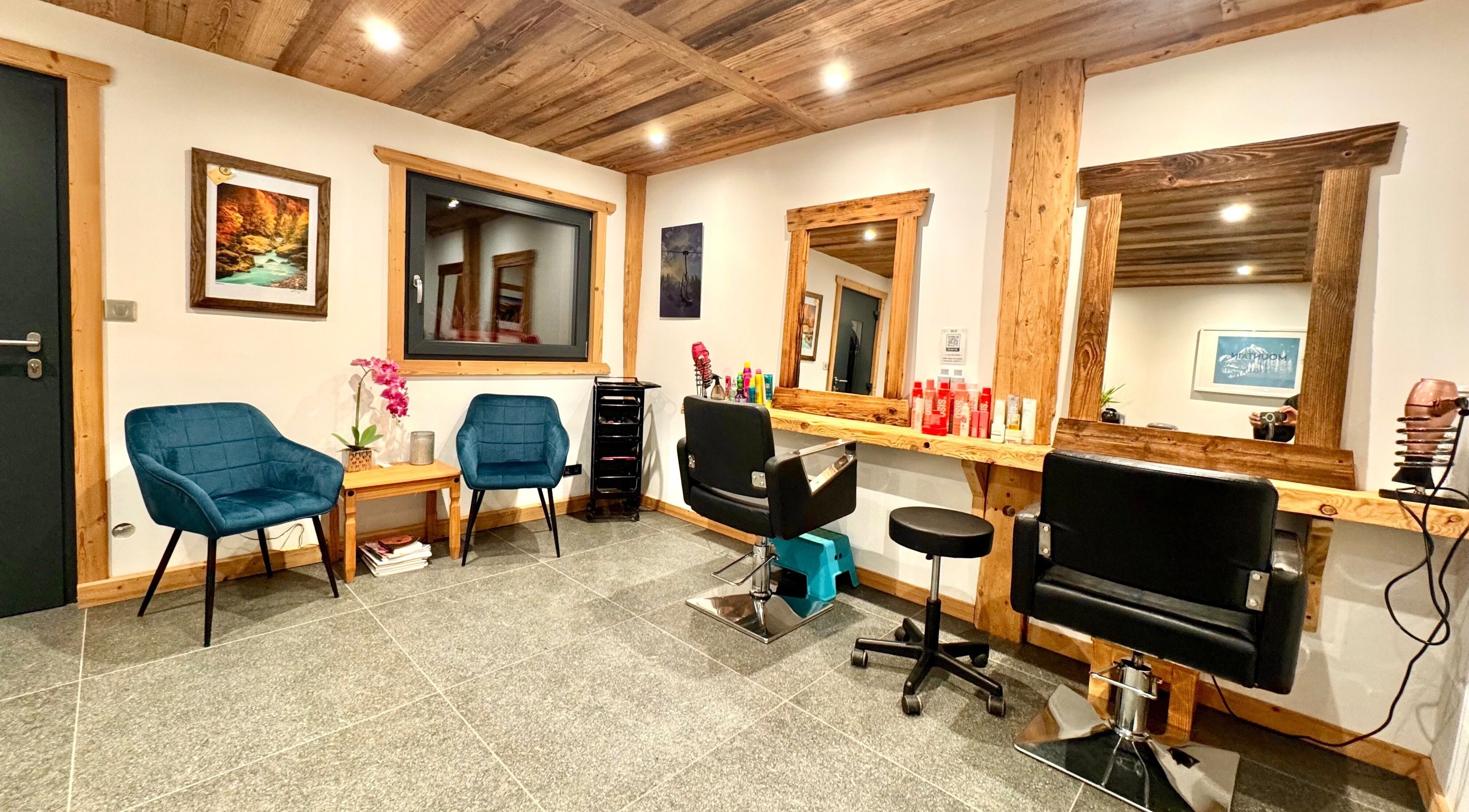 Interior of Mountain Hair salon in La Côte-d'arbroz, Auvergne-rhône-alpes, FR. Cozy seating and wood decor.