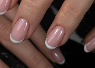 Elegant French manicure at Gelvibes, Montréal, Québec, CA, showcasing glossy pink nails with white tips.
