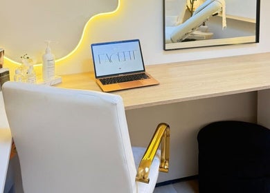 Modern desk area at Roots & Rituals Salon Inverness, Inverness, Scotland, GB, with laptop and skincare products.