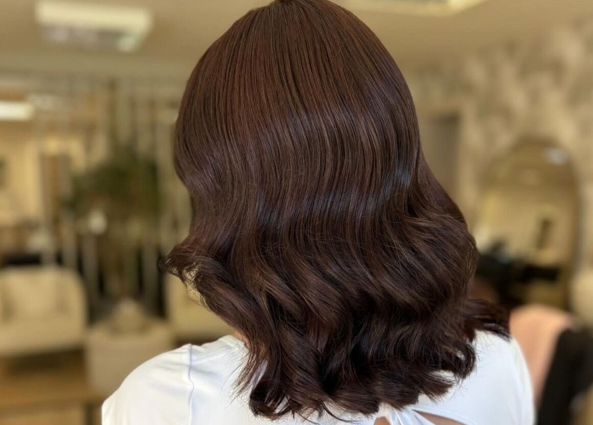 Elegant wavy hairstyle at Roots & Rituals Salon Inverness, Scotland, GB, showcasing glossy brown hair.
