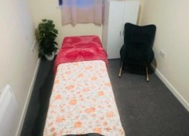 Relaxing massage room at Glimmerbeauty, London, England, GB, featuring a bed and cozy decor.