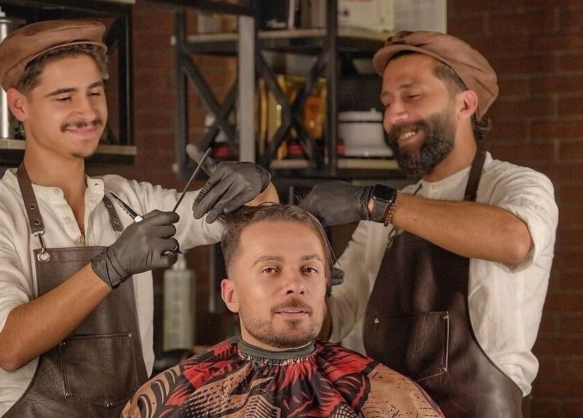 Expert barbers at Bekky Barber - Burj Vista in دبي, دبي, AE styling a man's hair with precision.
