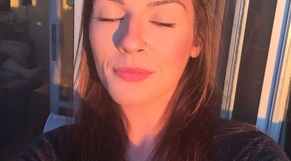 Woman basks in golden sunlight at Good Juju Holistic, Melbourne, Victoria, AU, promoting wellness and peace.