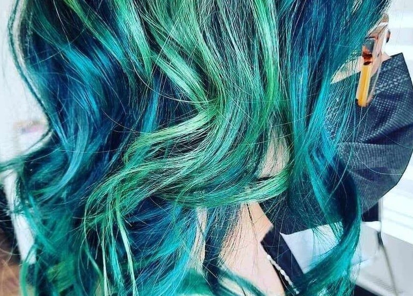 Chevelure bleu vert colorée chez Les Têtus à Trois-Rivières, Québec, CA, reflétant créativité et style.
