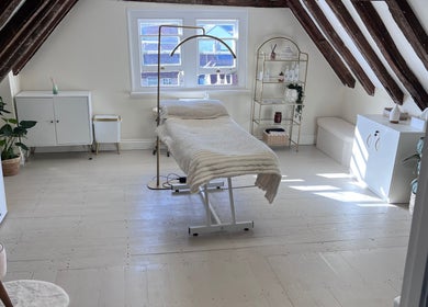 Peaceful treatment room at FX Aesthetics and Beauty, Chichester, England, GB with warm decor and natural light.