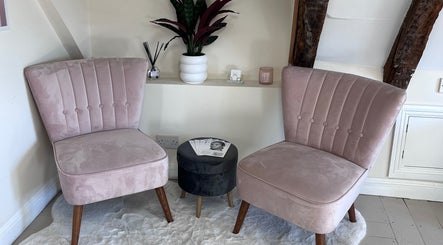 Chic seating area at FX Aesthetics and Beauty in Chichester, England, GB with plush pink chairs and decor.