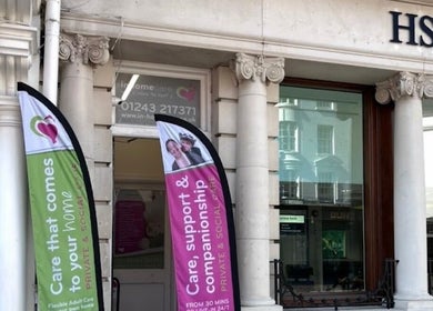 Entrance of FX Aesthetics and Beauty in Chichester, England, GB showcasing elegant columns and vibrant banners.