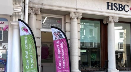 Entrance of FX Aesthetics and Beauty in Chichester, England, GB showcasing elegant columns and vibrant banners.