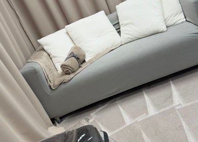 Cozy seating area at Beauty by Dionne, Stockport, England, GB, featuring a plush sofa with soft pillows and blanket.