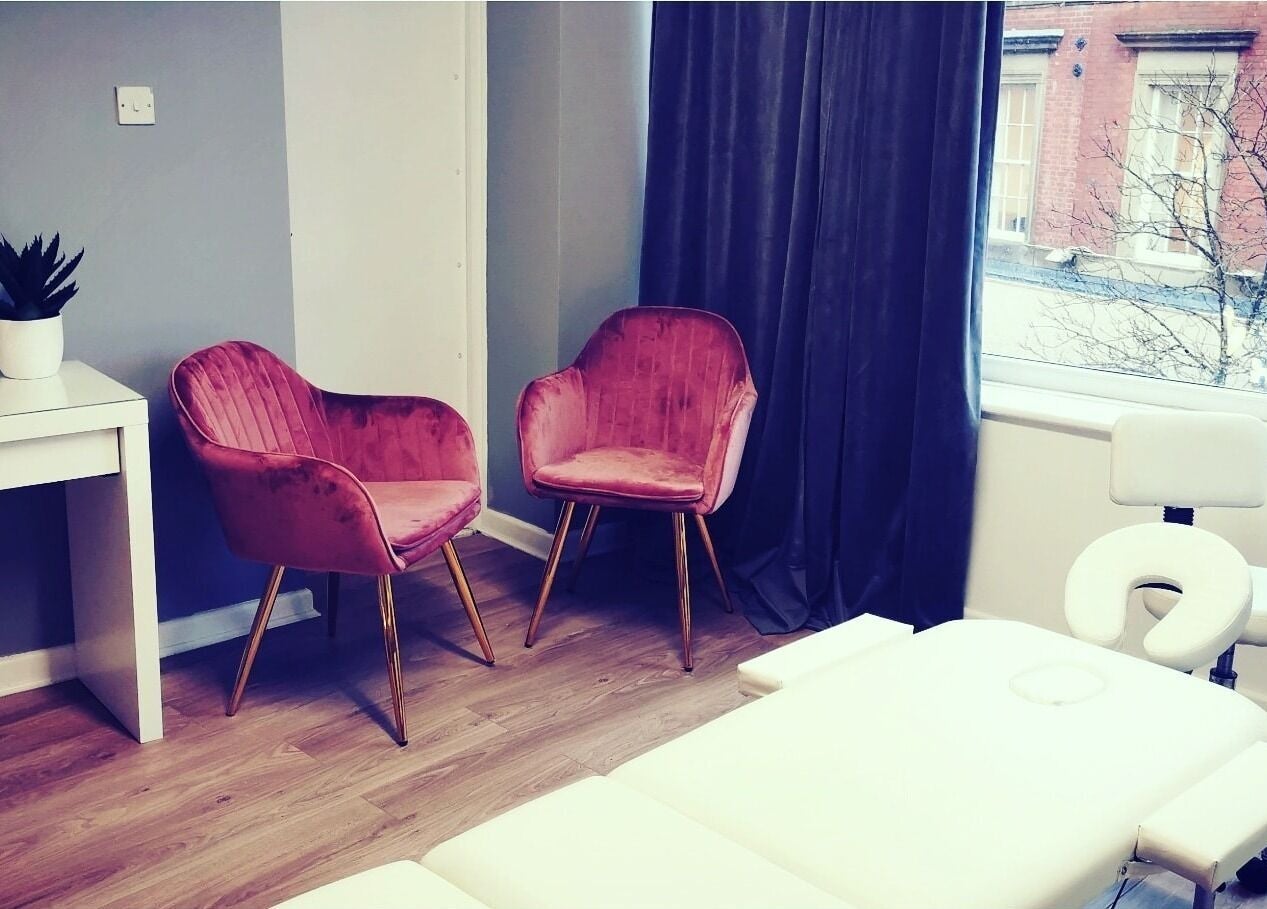 Relaxing treatment room at Glowmeup, Rochdale, England. Features stylish chairs and a cozy massage table.