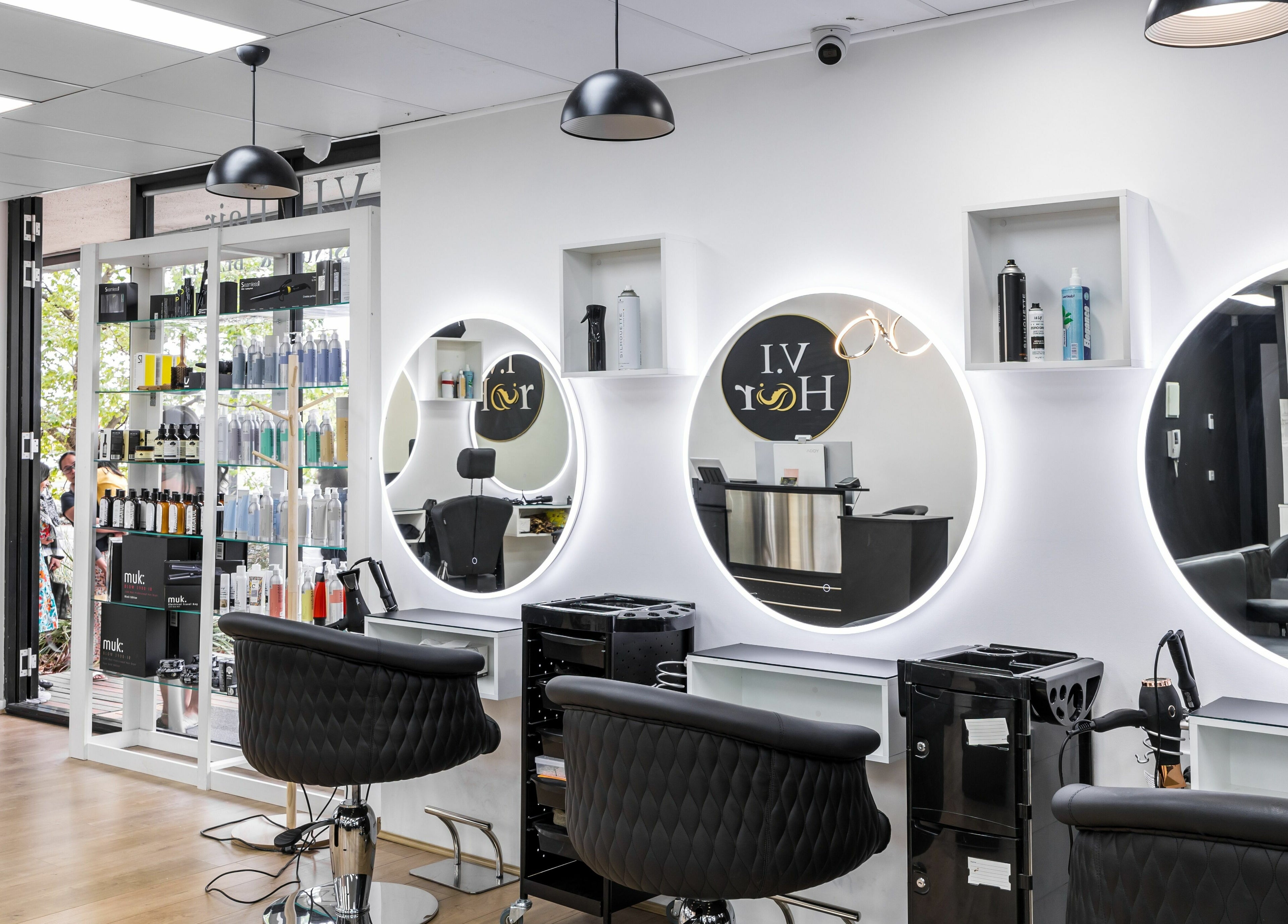 Modern salon interior of V.I Hair in Melbourne, Victoria, AU with sleek styling chairs and illuminated mirrors.
