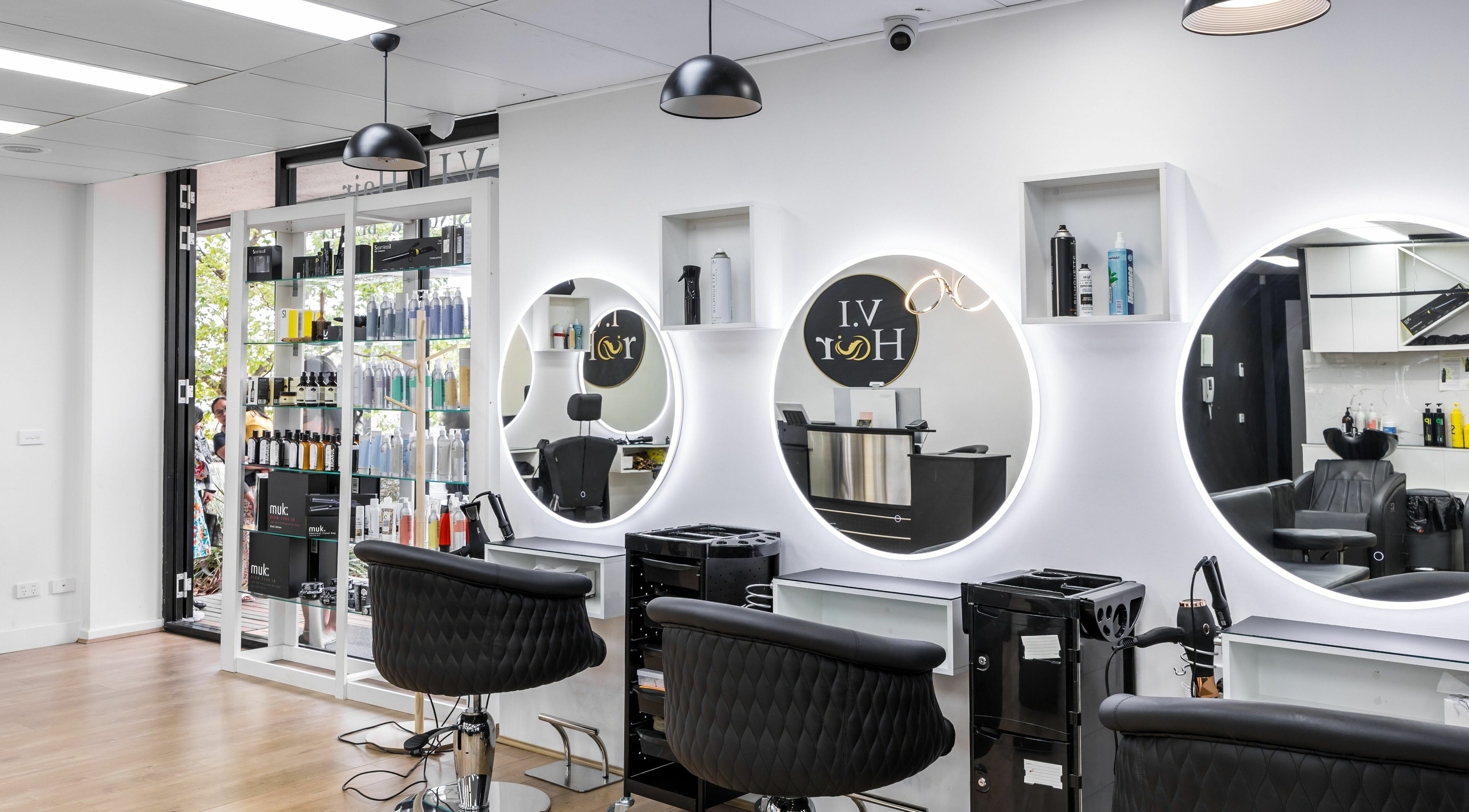 Modern salon interior of V.I Hair in Melbourne, Victoria, AU with sleek styling chairs and illuminated mirrors.