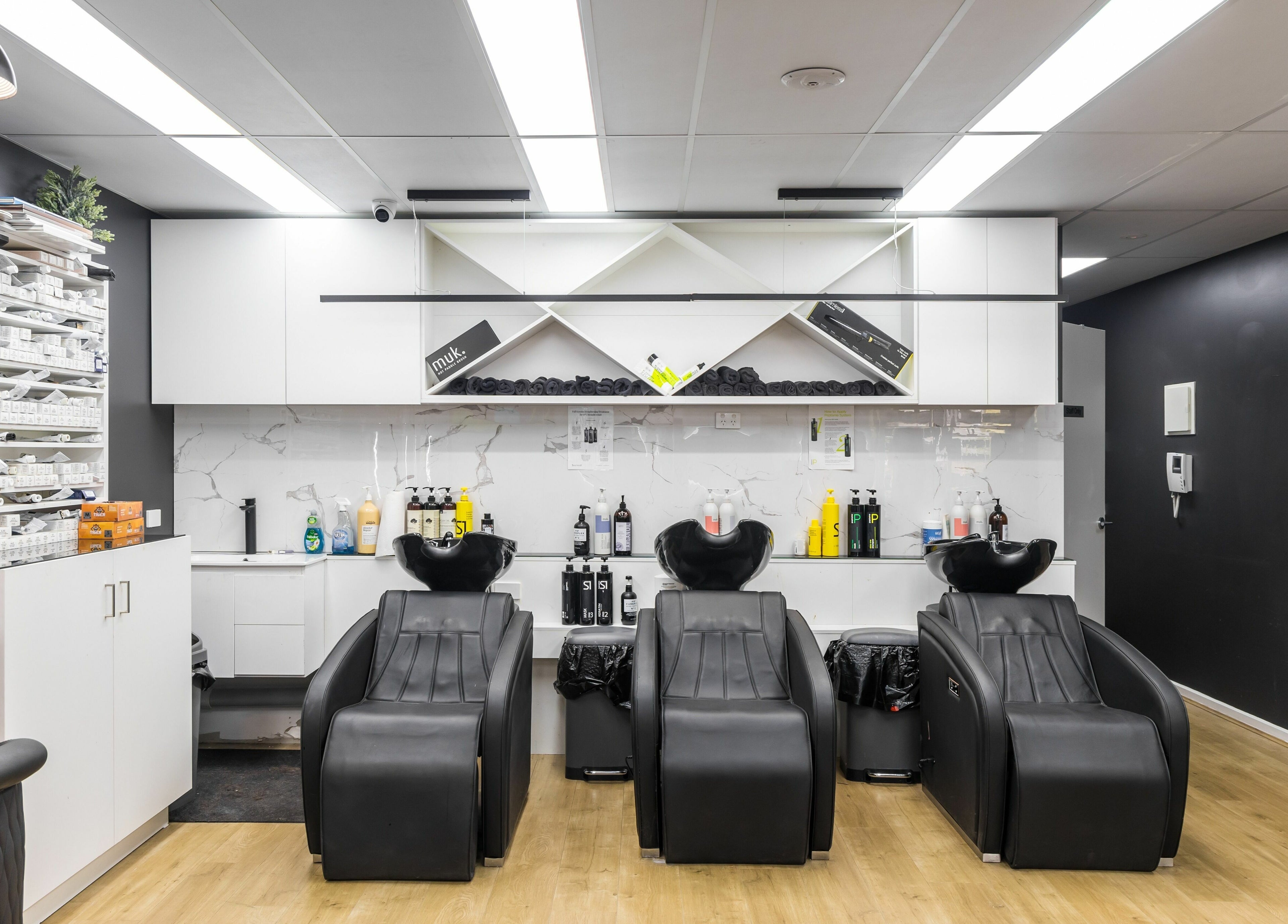 Modern hair salon at V.I Hair in Melbourne, Victoria, AU featuring sleek wash stations and product shelves.