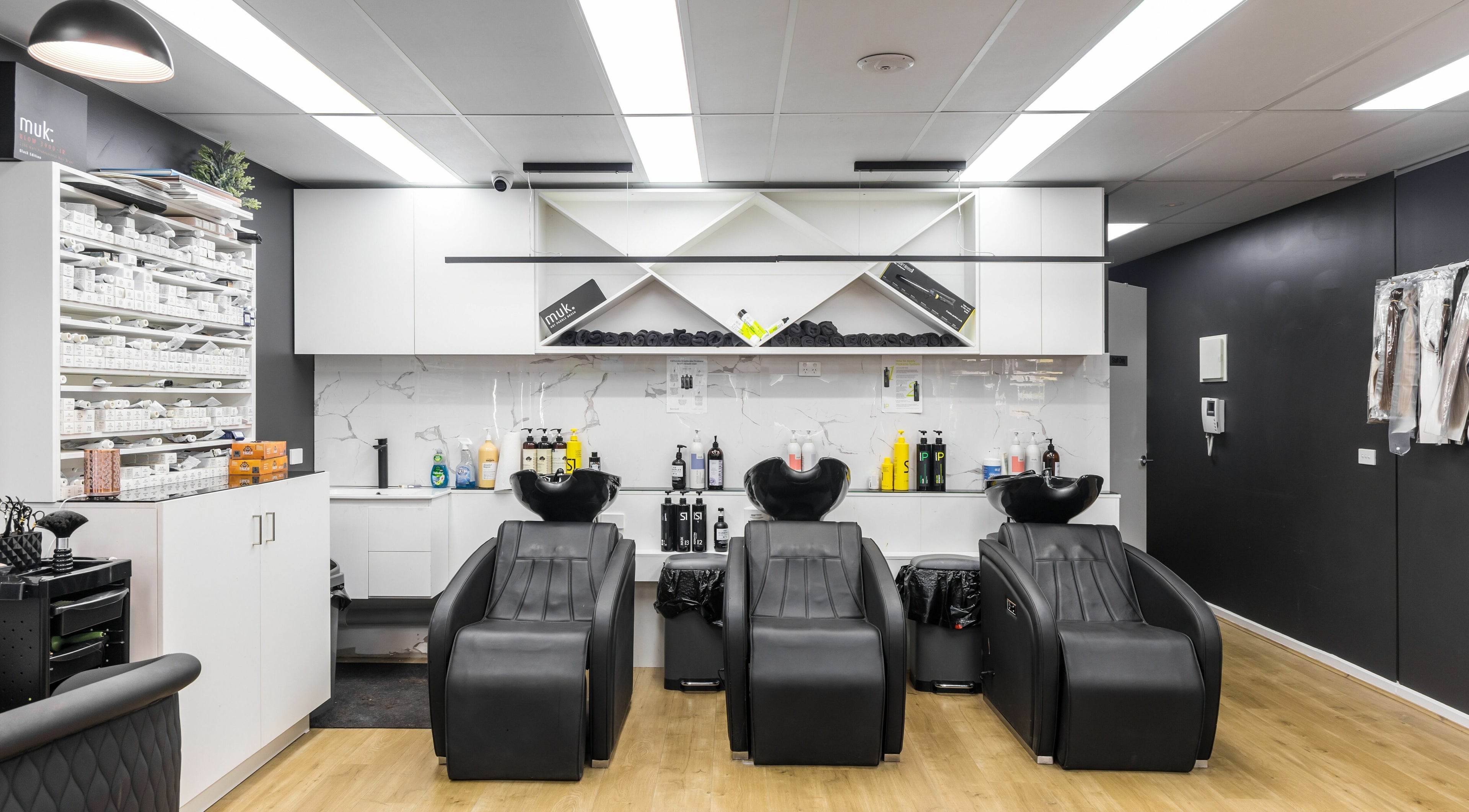 Modern hair salon at V.I Hair in Melbourne, Victoria, AU featuring sleek wash stations and product shelves.