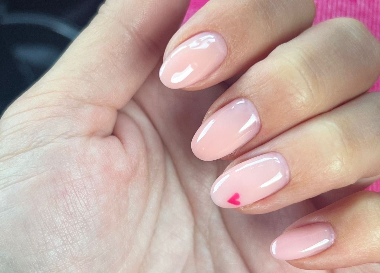 Close-up of manicured pink nails with heart design at It's a Gel Thing, Birmingham, England, GB.