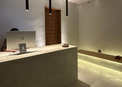 Minimalist reception desk at Koya Spa, Bali, Bali, ID with ambient lighting and computer.