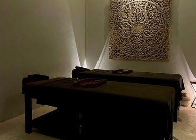 Elegant massage room at Koya Spa Seminyak, Bali, Bali, ID, featuring twin beds and intricate wall art.