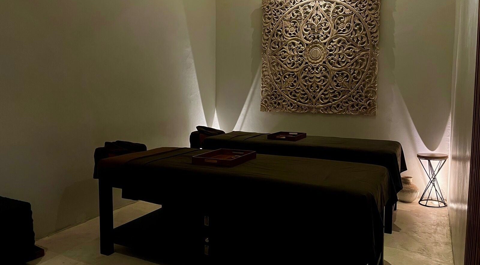 Elegant massage room at Koya Spa Seminyak, Bali, Bali, ID, featuring twin beds and intricate wall art.