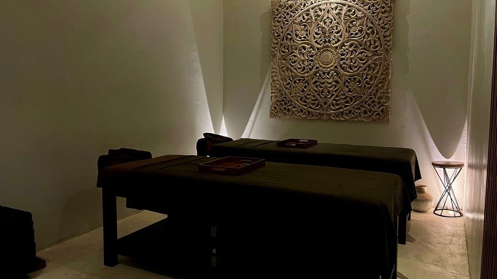 Elegant massage room at Koya Spa Seminyak, Bali, Bali, ID, featuring twin beds and intricate wall art.
