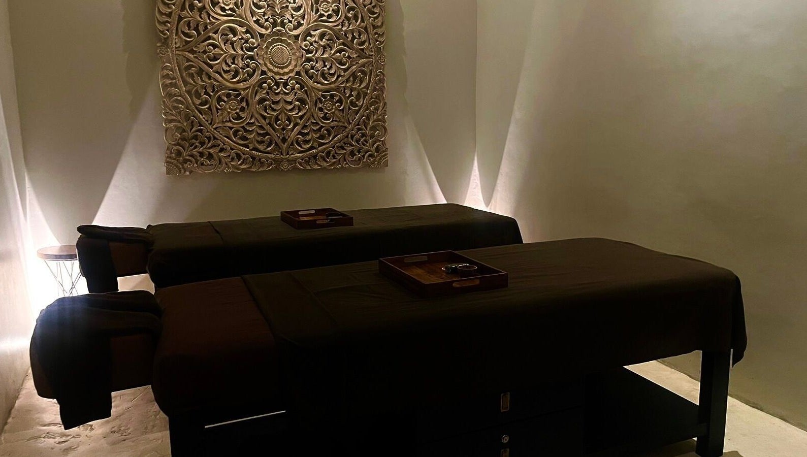 Tranquil massage room at Koya Spa, Bali, Bali, ID with ambient lighting and intricate wall art.