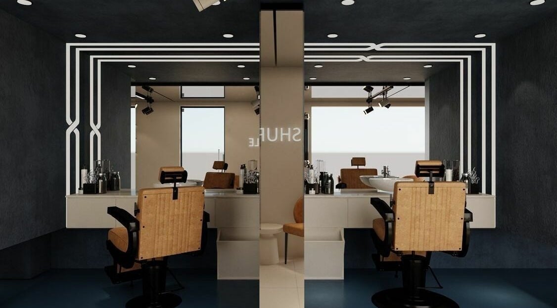 Interior of Shuffle Gents Barber in Mubarak Al-kabeer Governorate, featuring sleek chairs and modern decor.