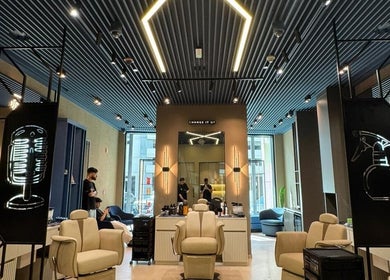 Interior of SHUFFLE Gents Salon Hessah District at Al Asimah Governate, showcasing stylish chairs and modern decor.
