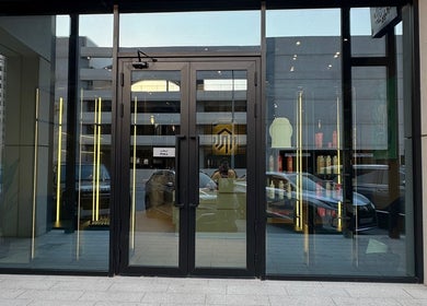 Entrance of SHUFFLE Gents Salon Hessah District in Al Asimah Governate, KW, with sleek glass doors.