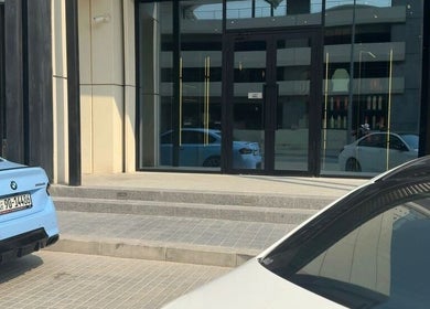 Front view of SHUFFLE Gents Salon Hessah District in Al Asimah Governate, KW showcasing modern glass facade.
