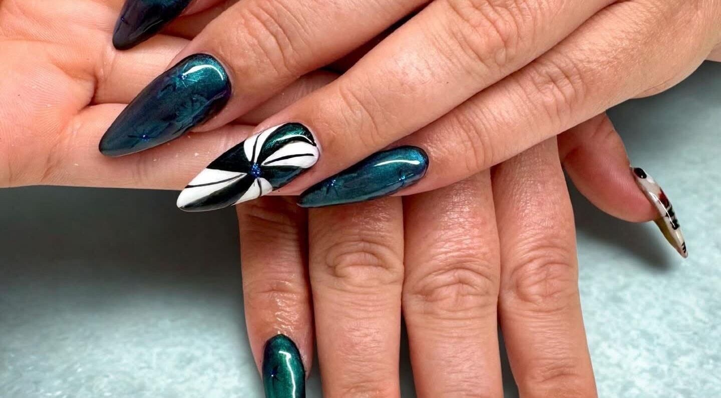 Intricate nail art design at Afterglow Beauty, Cambridge, England, GB showcasing teal polish and floral pattern.