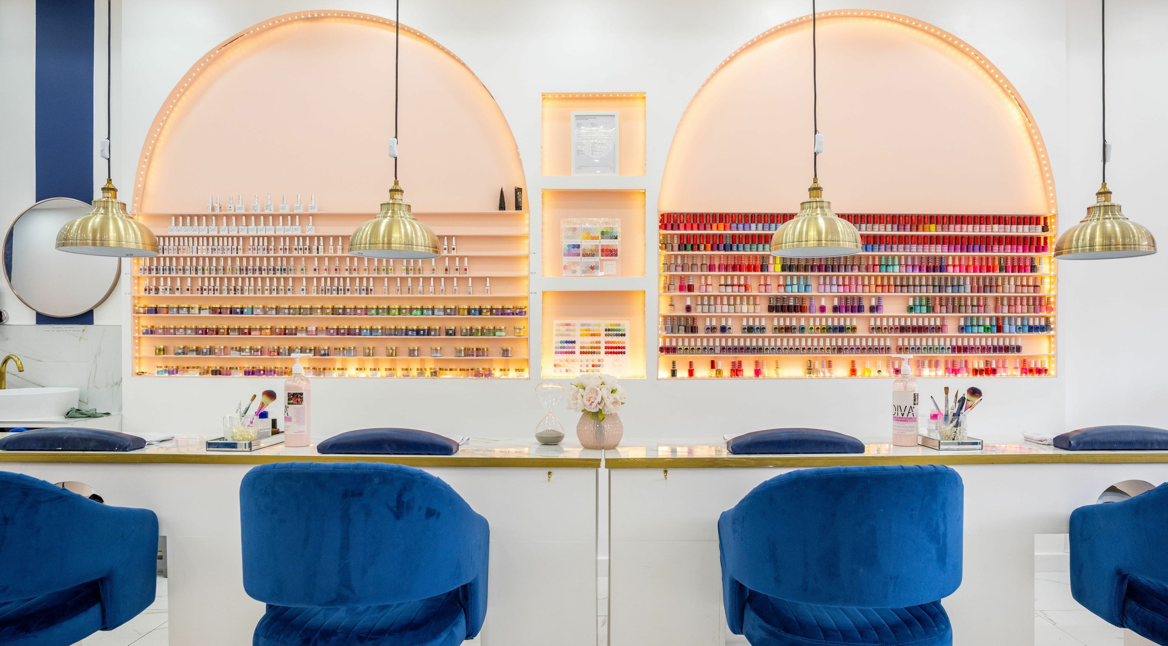 Vanity Nail Bar in Brierley Hill, England showcases a chic manicure setup with vibrant polish on lit shelves.