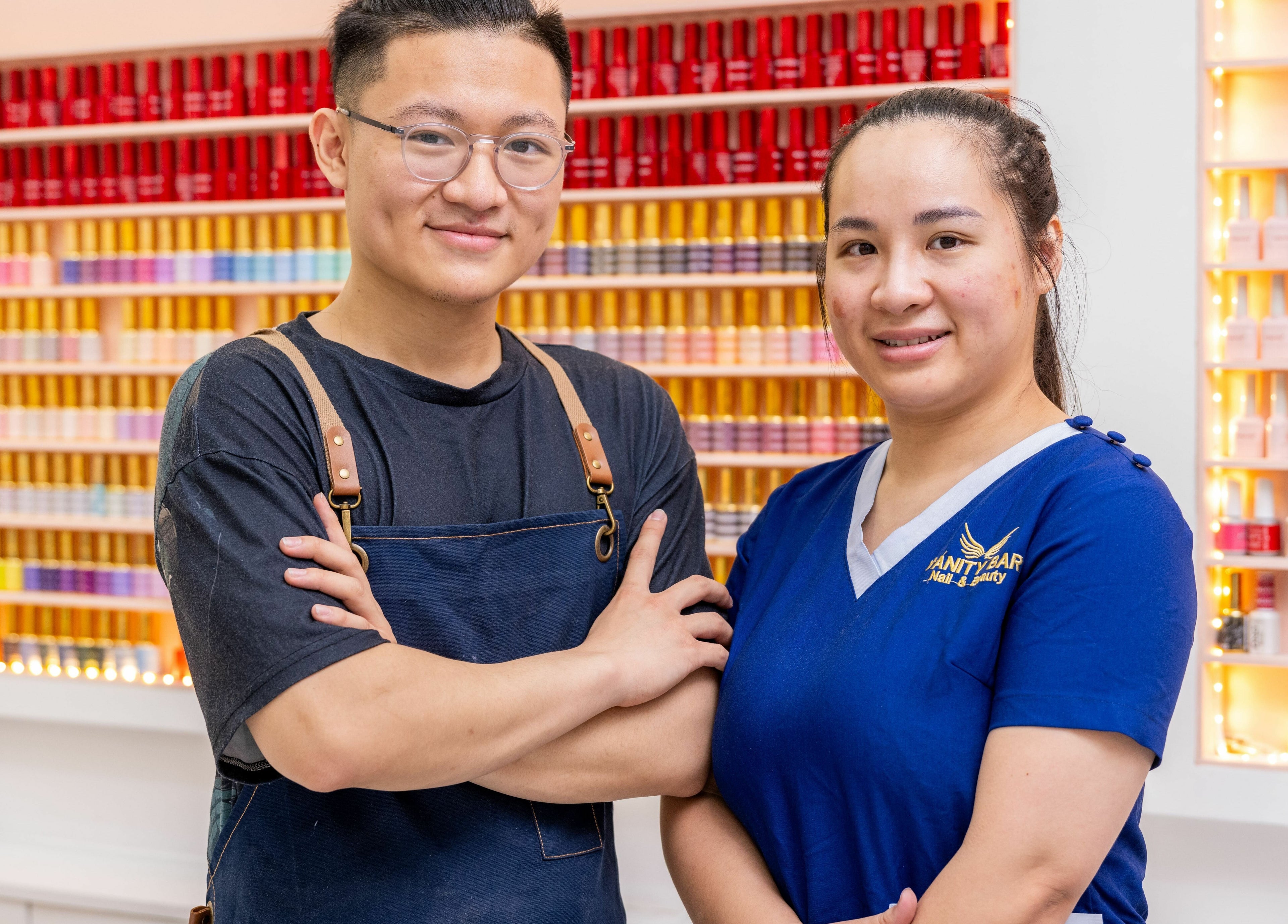 Friendly staff at Vanity Nail Bar, Brierley Hill, England, GB, amid colorful nail polish collection.