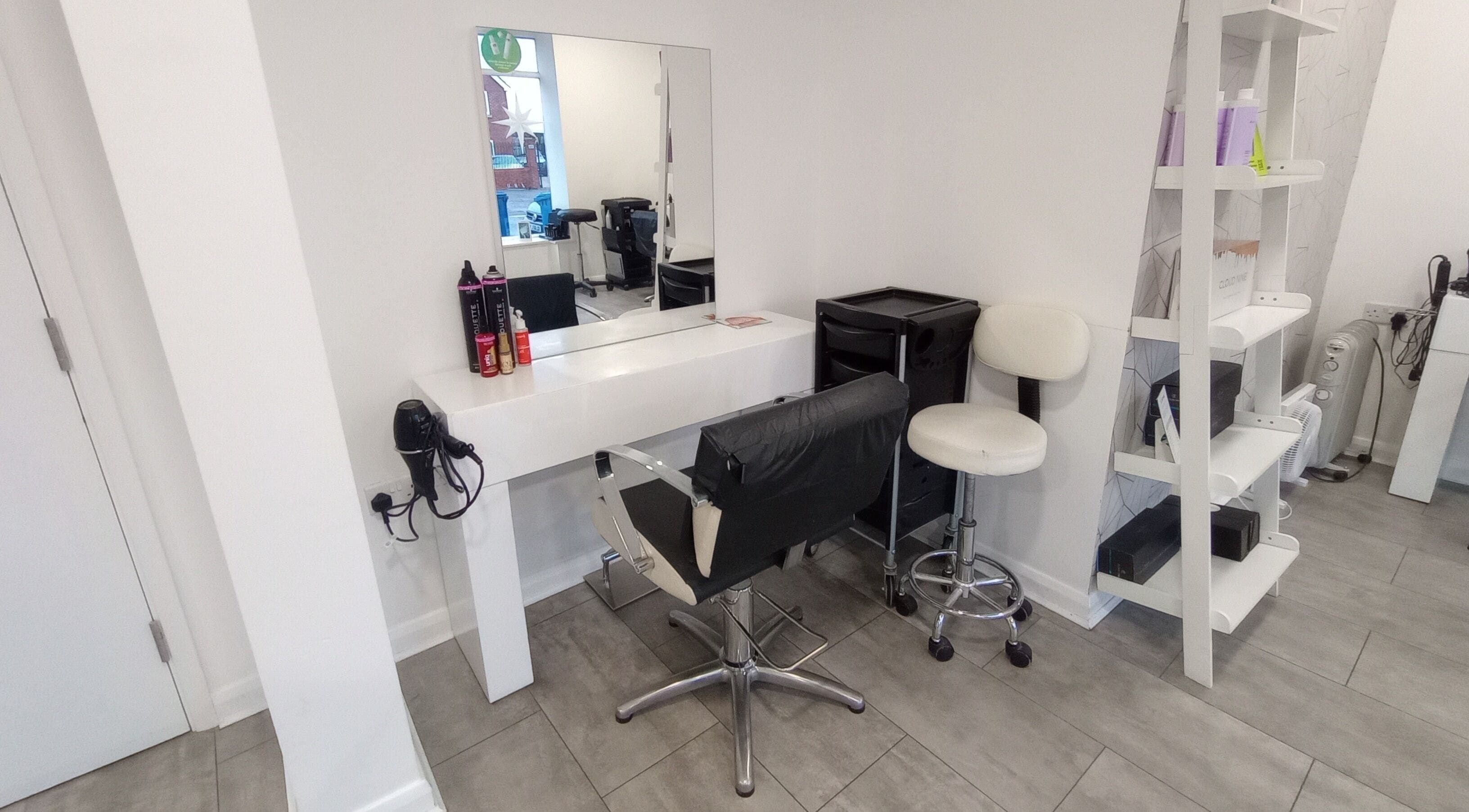 Modern salon setup at Emily H at Roots, Windsor, England, GB. Stylish mirror, chair, and products on display.
