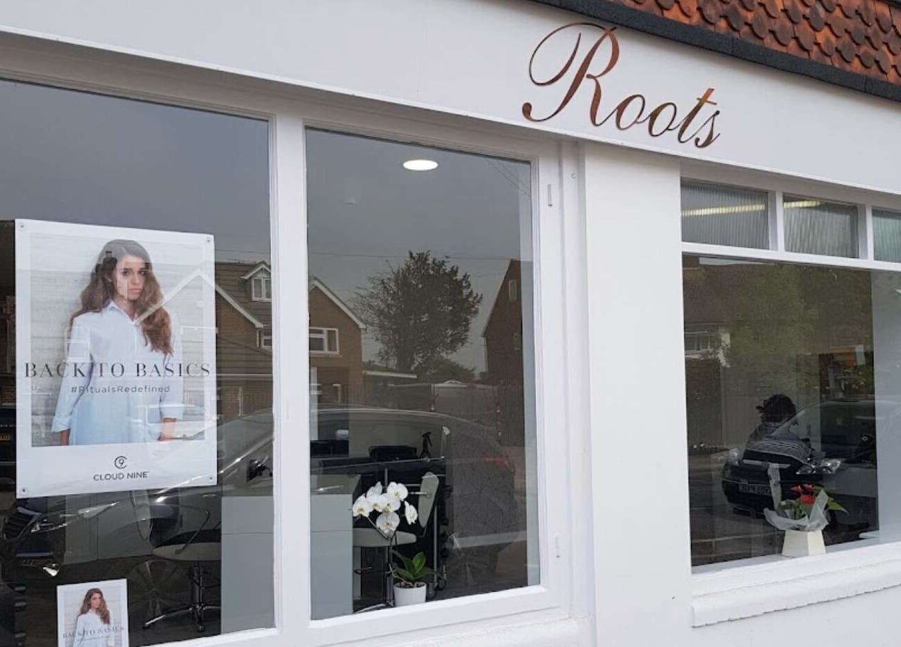 Exterior of Emily H at Roots salon in Windsor, England, GB showing large windows and elegant signage.