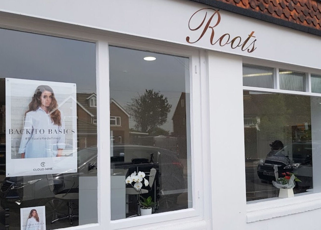 Exterior of Emily H at Roots salon in Windsor, England, GB showing large windows and elegant signage.