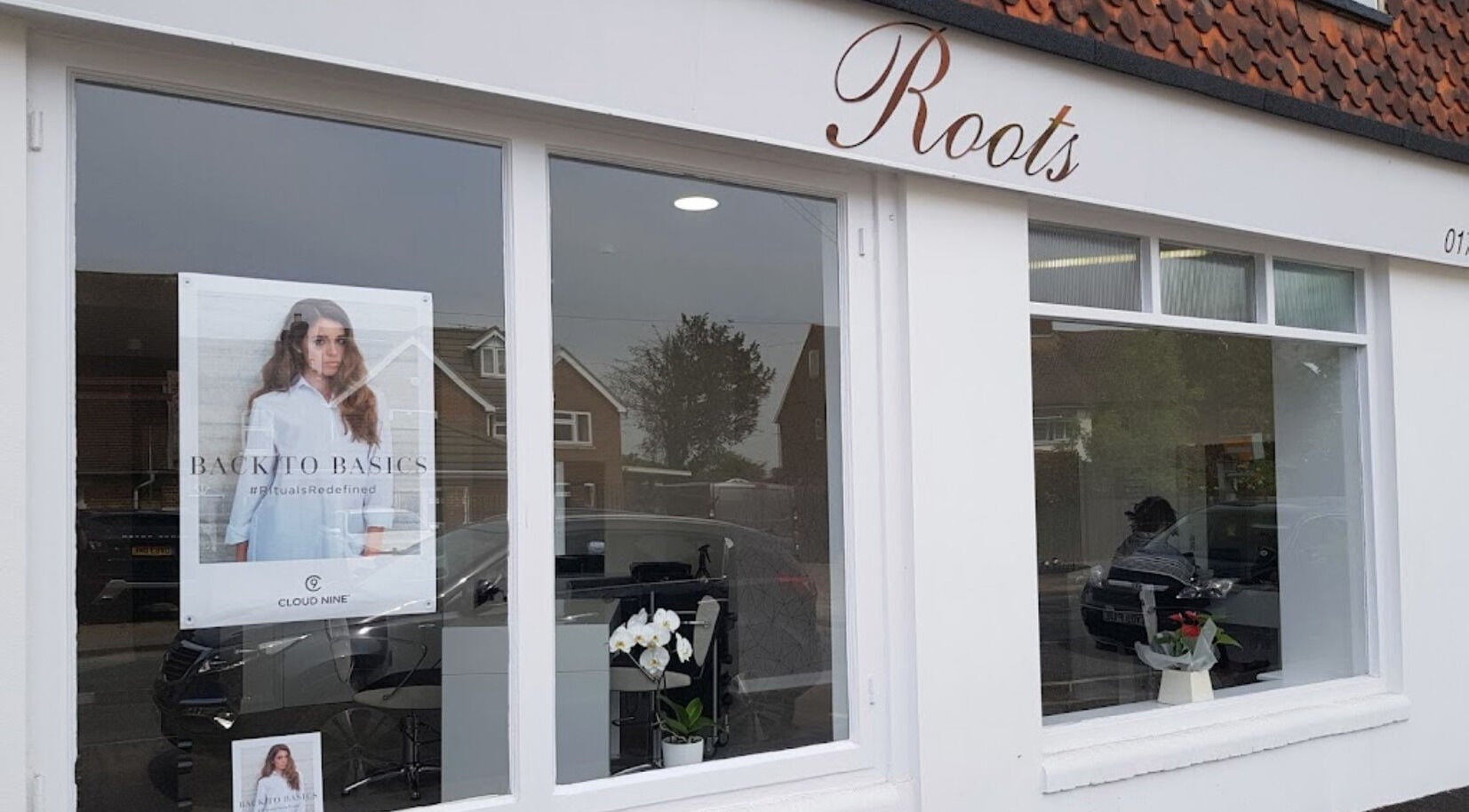 Exterior of Emily H at Roots salon in Windsor, England, GB showing large windows and elegant signage.